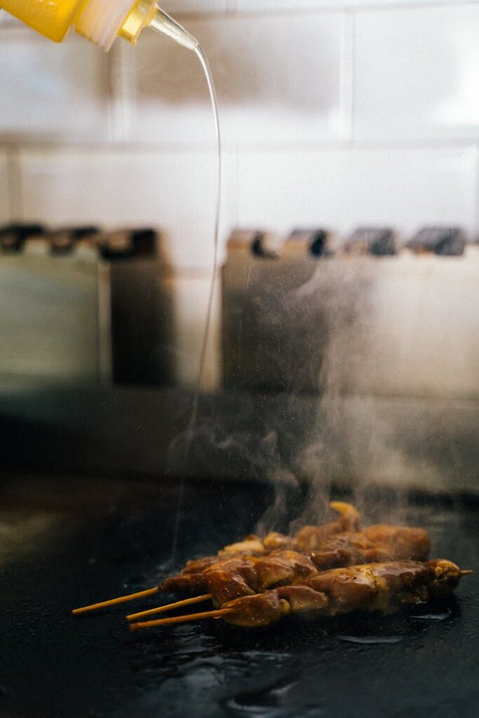 Pouring oil over a Skewered Meat